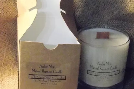 a candle sitting next to a box of brown paper